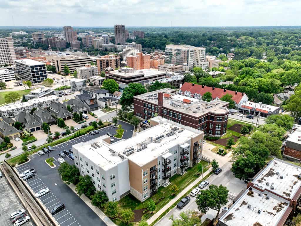 West Hill Apartments, originally an elementary school built in 1914, features unique layouts and abundant windows. Select units retain the original wooden gym floors. The complex includes studio, 1, 2, and 4-bedroom options across two buildings. Amenities include a rooftop lounge, BBQ grills, two fitness centers with Wellbeats Digital Trainer, a garden lounge with a fire pit, and more.